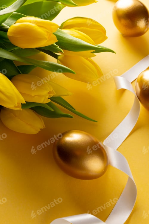 Preview: Image of gold easter eggs with yellow tulips and copy space on yellow background