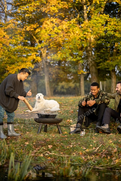 Preview: Male friends resting and fishing on lake coast