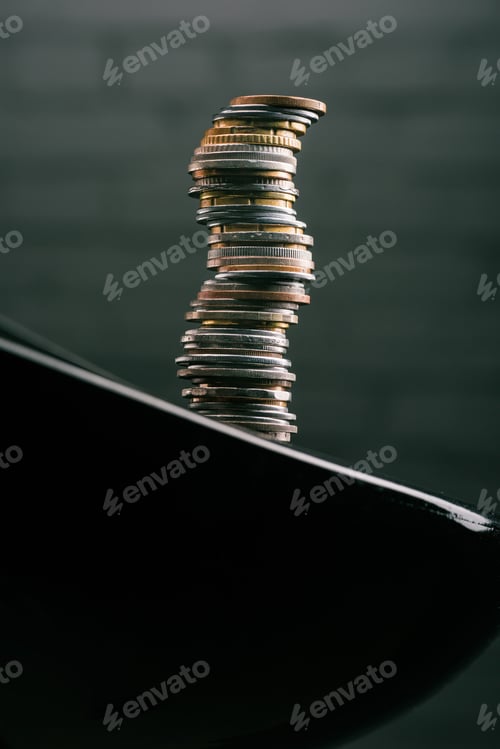 Preview: close up view of stack of different coins standing on edge of table