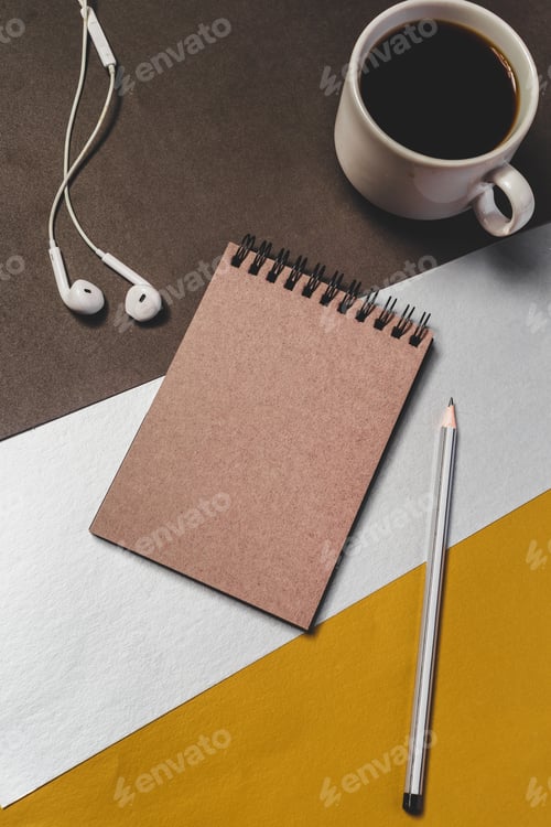 Preview: Notebook, pencil, earphones, and coffee on a table with colored paper