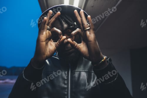 Preview: portrait of young black man standing outdoor showing hands