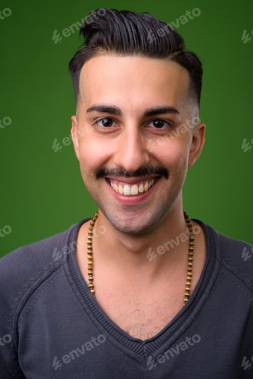 Preview: Young handsome Iranian man with mustache against green backgroun