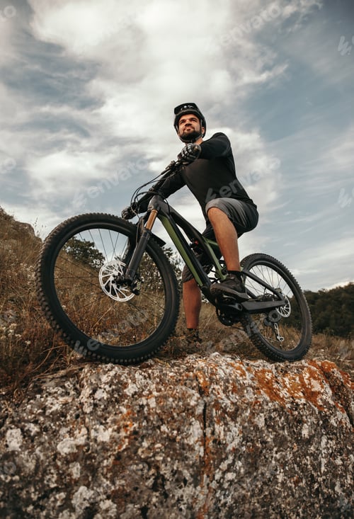 Preview: Confident male cyclist on bike in mountains