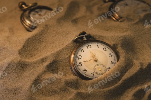 Preview: Vintage pocket watches on the sand.