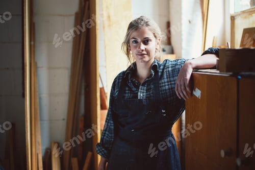 Preview: Portrait of young craftswoman leaning on cupboard in organ workshop