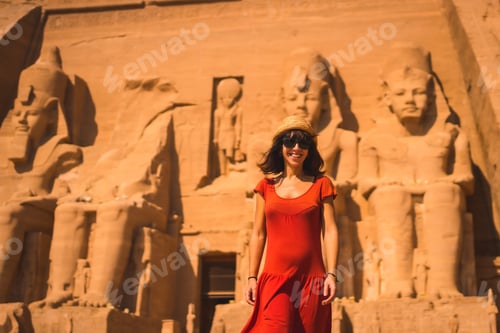 Preview: A Young Tourist In A Red Dress Smiling At The Abu Simbel Temple In Southern Egypt In Nubia Next To