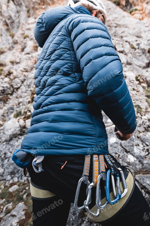 Preview: Climbing equipment, carabiners, hanging from the harness of a man while climbing