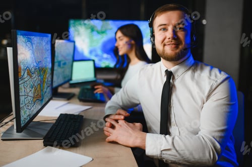 Preview: Control room dispatcher smiling wearing headset at workstation