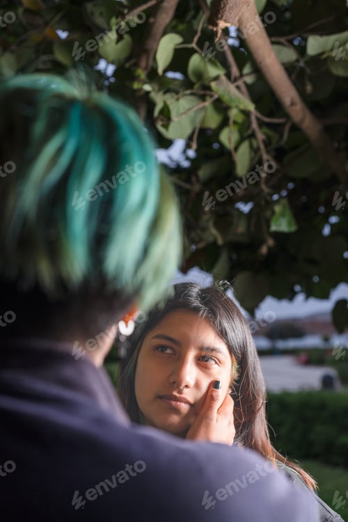 Preview: Focus on a lesbian woman caressing the face of her lover in a park