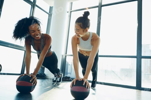 Preview: Two young women working out in gym, using gym equipment