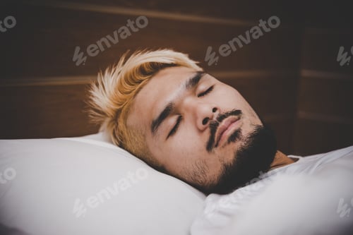 Preview: Handsome young beard man sleeping in white bedding.