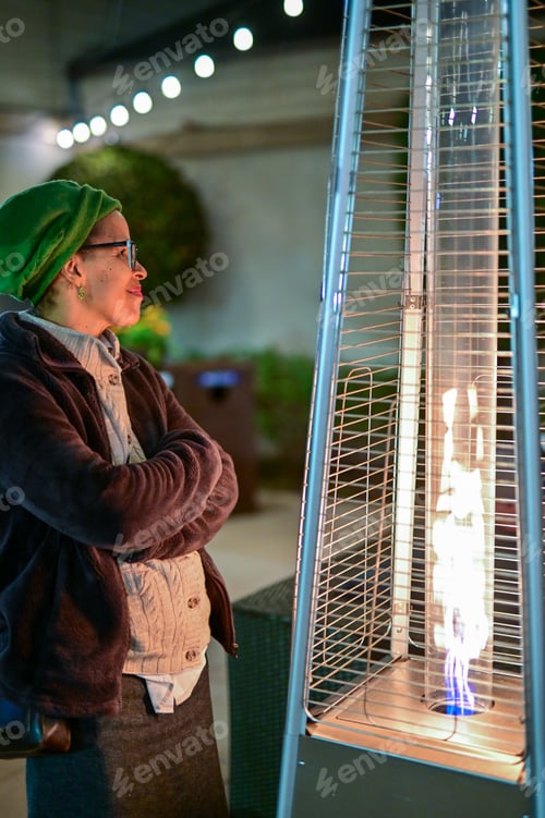 Preview: Woman Warms Up Herself Next To an Outdoor Tower Heater