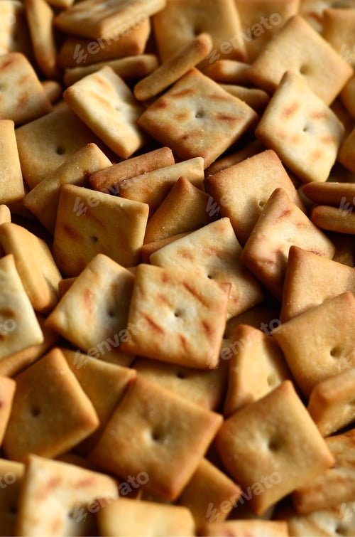 Preview: A lot of small cookies are square shaped. A pattern of a yellow salt cracker. Background