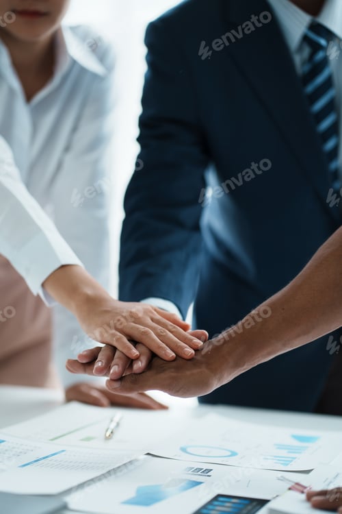 Preview: Young business people putting their hands together. Stack of hands. Unity and teamwork concept.