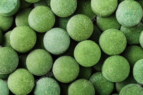 Preview: Chlorella or spirulina tablets close up. Top view. Texture of tablets spirulina or chlorella.