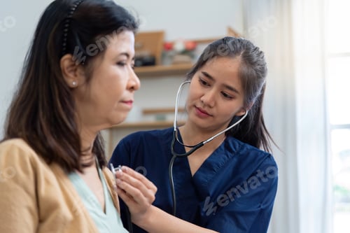 Preview: Caregiver using a stethoscope to examine elderly patient during health assessment