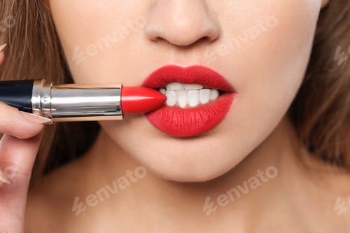 Preview: Young woman holding red lipstick, closeup view