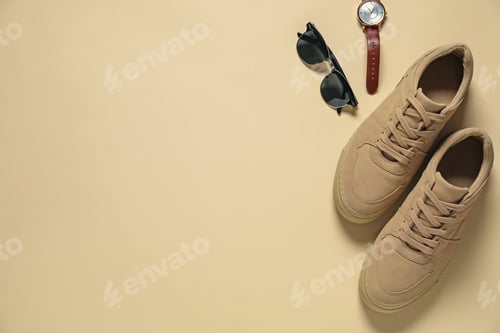 Preview: Stylish sneakers, sunglasses and wristwatch on beige background, flat lay