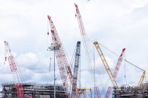 Preview: Construction site with construction crawler cranes and multi storey unfinished buildings