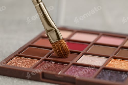 Preview: Colorful eyeshadow palette with brush on grey table, closeup view
