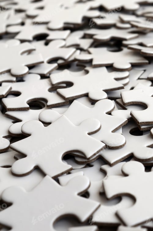 Preview: Close-up of a pile of uncompleted elements of a white puzzle