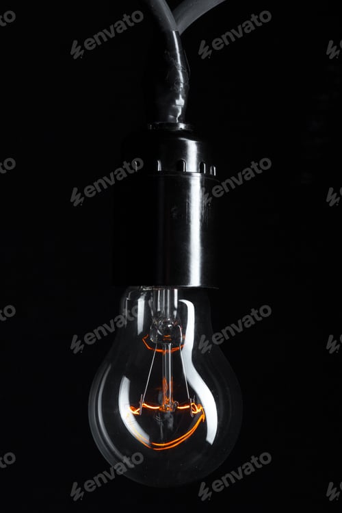 Preview: A classic Edison light bulb on dark background with space for text