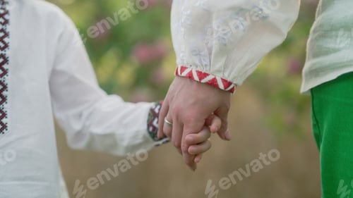 Preview: Ukrainian mom and child holding hands together, family background. Mother hand