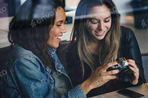Preview: two female mixed race friends having a coffee and chatting