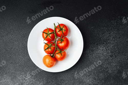 Preview: Freshly harvested tomatoes on a white plate against a dark background