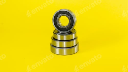 Preview: Closeup shot of ball bearings stacked on top of each other on a yellow background