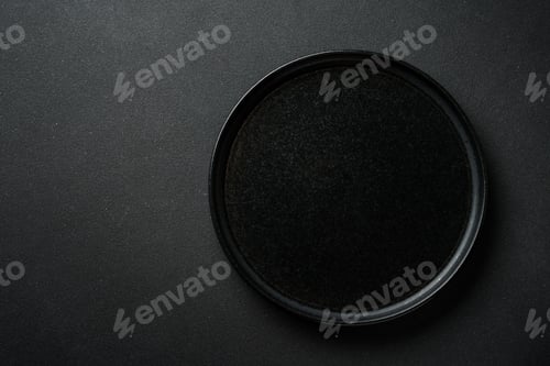Preview: Black plate at black background. Top view with space for text.