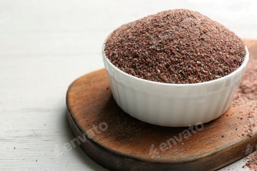 Preview: Black salt in bowl on white wooden table. Space for text