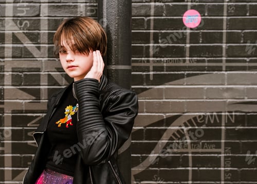 Preview: Young teen with black leather jacket and simpsons shirt poses in front of OKC map mural