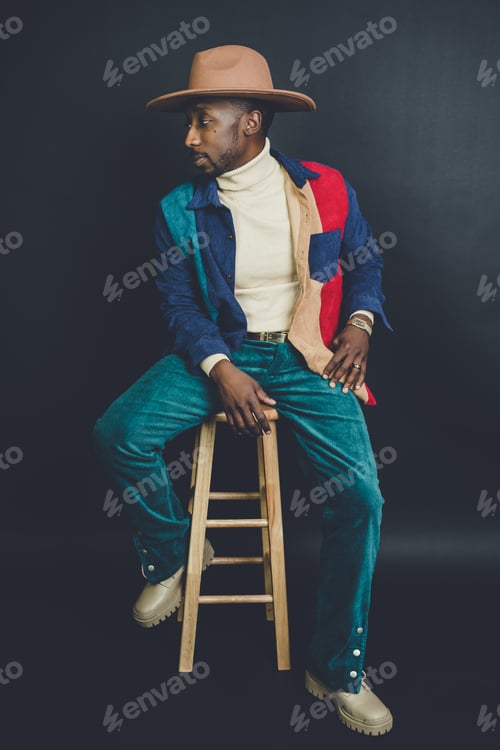 Preview: African American man from US in a hat and casual outfit posing in a photo studio
