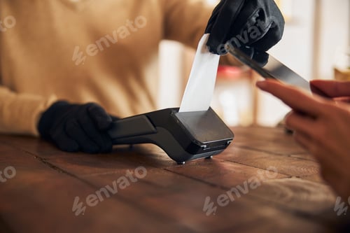 Preview: Male worker using terminal for contactless payment