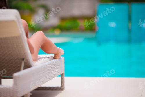 Preview: Woman sunbathing on a lounger at tropical resort