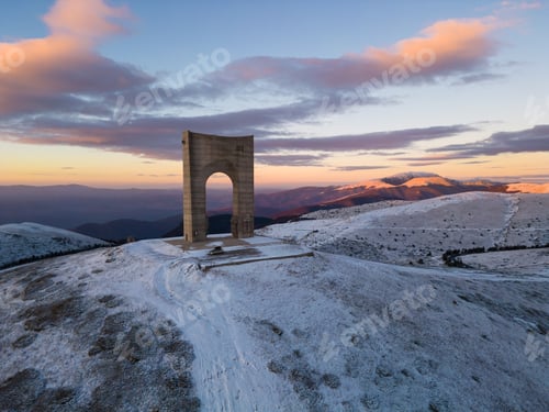 Preview: Beautiful aerial view of snow covered mountains and the Monument Arch of Liberty at the main ridge
