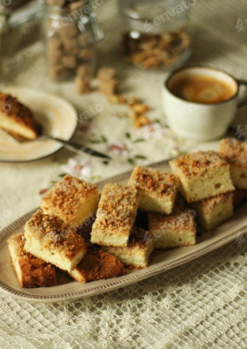 Preview: Cookies with nuts and sugar lie on a dish on the table next to a cup of coffee