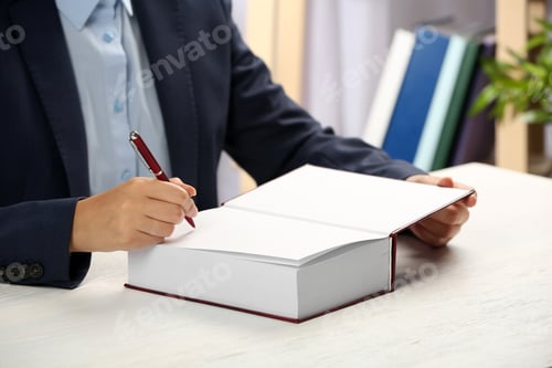 Preview: Writer signing autograph in book at table, closeup