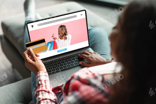 Preview: Black woman using laptop and credit card, making online order or payment, shopping in web store at