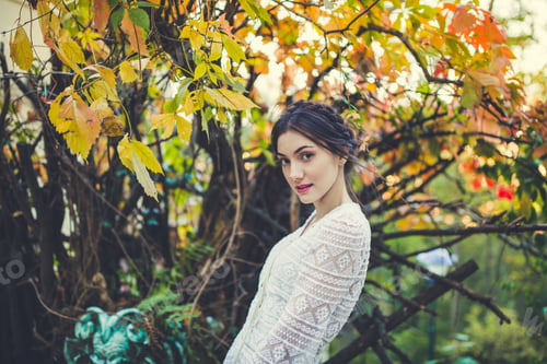 Preview: Beautiful girl in a white lace blouse in an autumn park