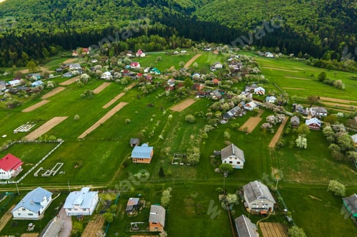 Preview: Aerial landscape view of village houses and distant green cultivated agricultural fields with