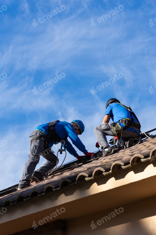 Preview: Solar panel installers working on the roof of a house