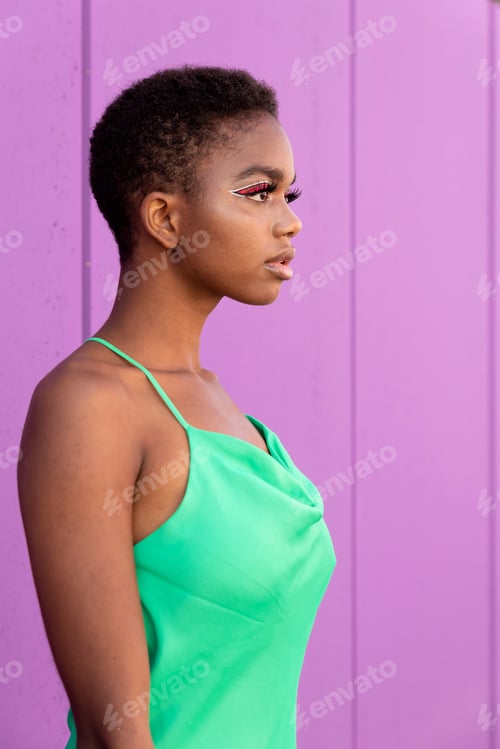 Preview: Stylish black woman with short hair in green dress in front of a lilac background
