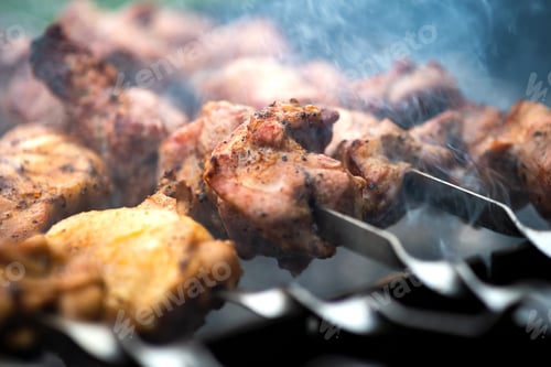 Preview: Shashlik or shish kebab preparing on barbecue grill over hot charcoal.