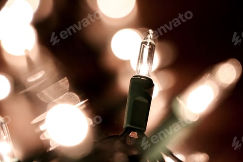 Preview: Close-up of a glowing Christmas light bulb with a blurred bokeh background