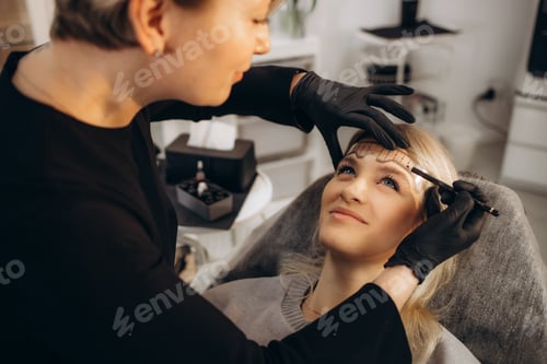 Preview: Cosmetician making measuring with ruler and getting ready to apply makeup to a client. Closeup shot