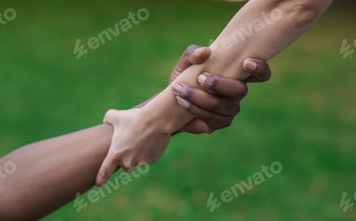 Preview: Multiethnic friends helping hand outdoor, copy space