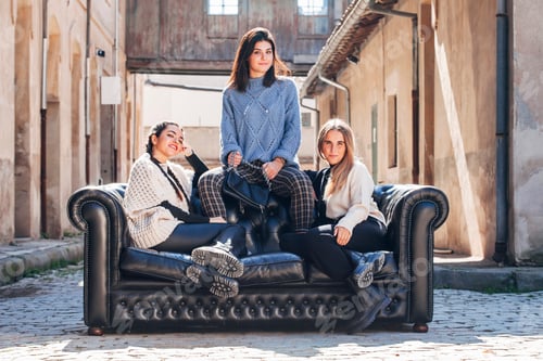 Preview: Stylish woman relaxing on sofa on street