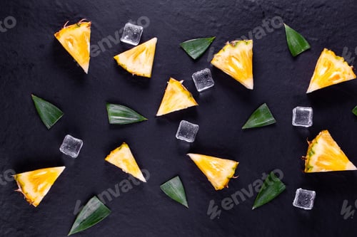 Preview: Fresh pineapple on black wood, black background.